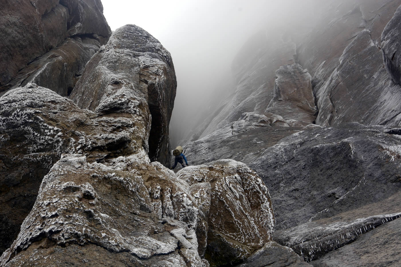 Severe humidity was constant on the climb. The men climbed to the summit in a narrow window of good weather. As they descended over the next three days, the wall alternated between cascades of water and frost-covered rock. Here Antoine Moineville rappels down the wall. [Photo] Silvan Schuepbach