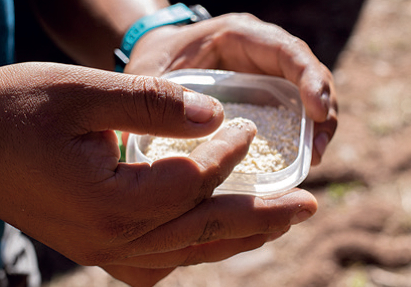 Necefer dips his fingers into white corn meal to give an offering to the mountain before ascending the couloir. [Photo] Len Necefer