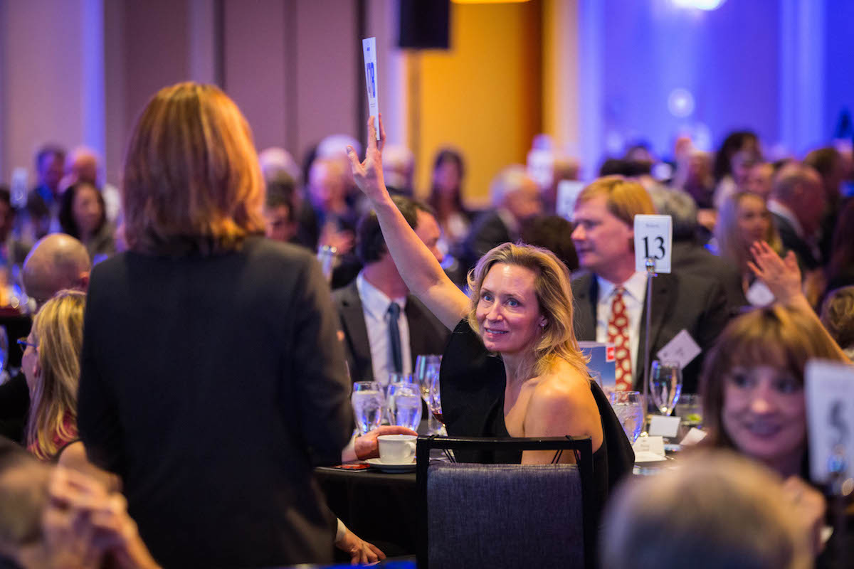 Carry Roberts places a bid at last year's event. [Photo] Jim Aikman