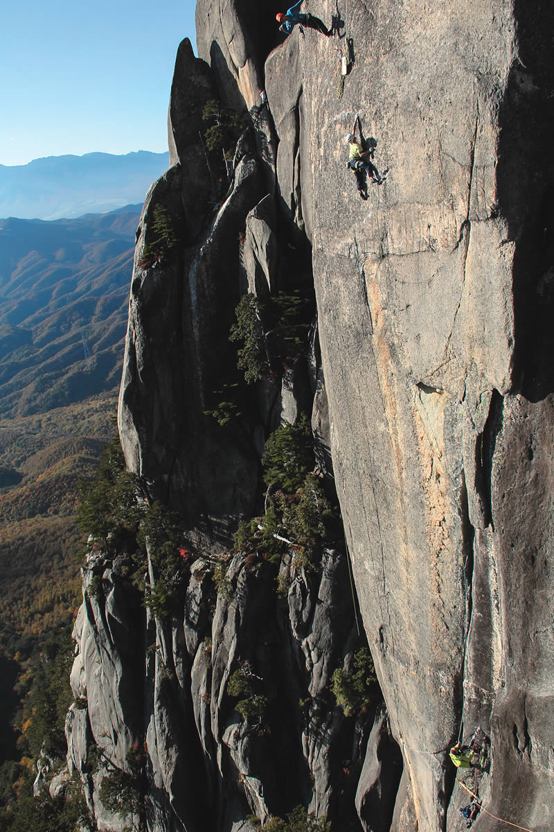 Keita Kurakami on the shakily protected deadpoint of Pitch 3 (5.14a R). Guidebook author Naoya Naito notes that Kurakami's decade of hard bouldering served as good training; he sees Kurakami's multipitch climb as "an indication of the infinite possibilities of climbing, audacious and beautiful." [Photo] Satoru Hagihara