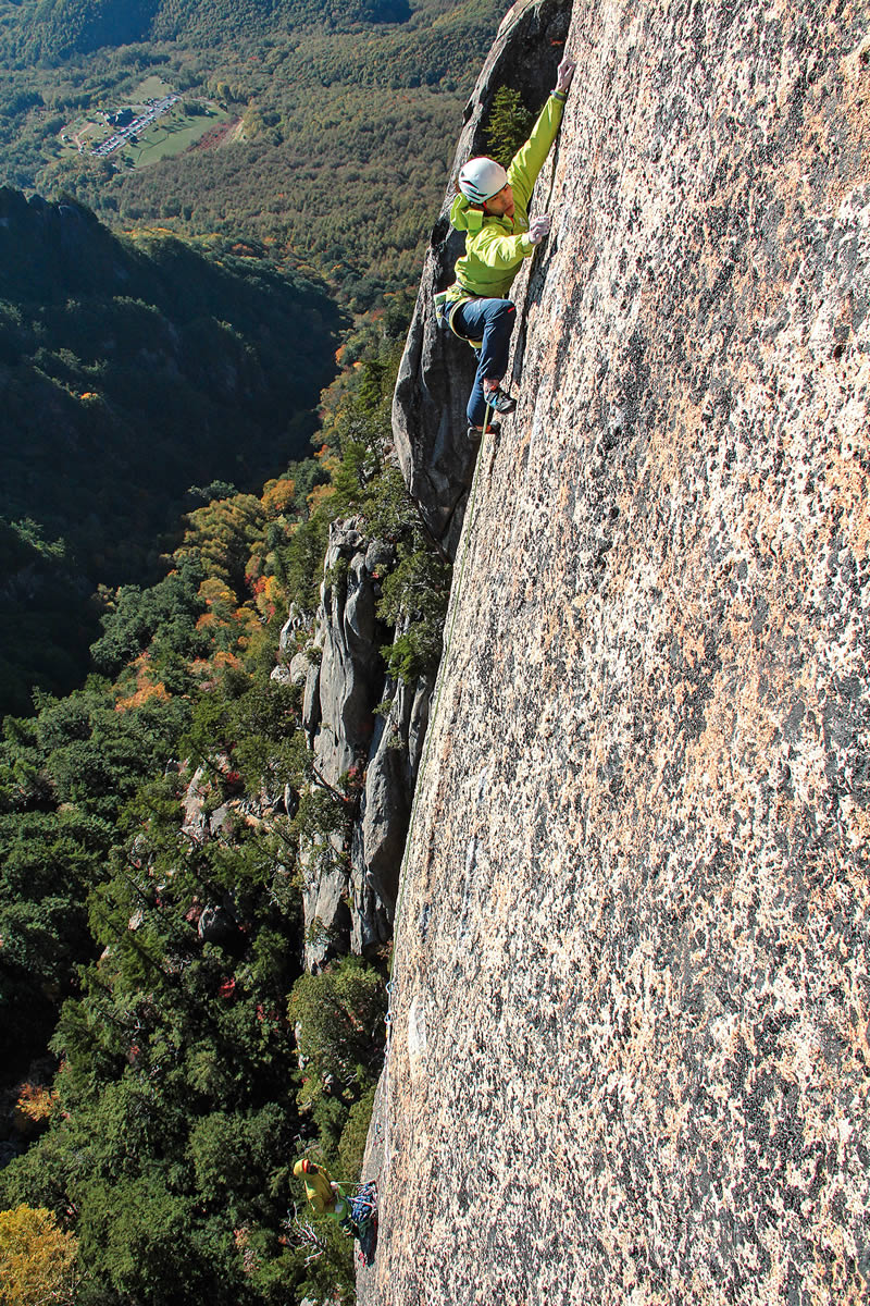 Kurakami twenty meters above his last piece of gear on Pitch 4 (5.13d R/X). In Alpinist 48, Yokoyama writes, "In traditional Japanese religion, people believed there must be gods...for rocks, waterfalls and mountains. It makes sense that Mt. Mizugaki would be a holy peak, its granite walls rising like a fortress from a deep forest." [Photo] Satoru Hagihara