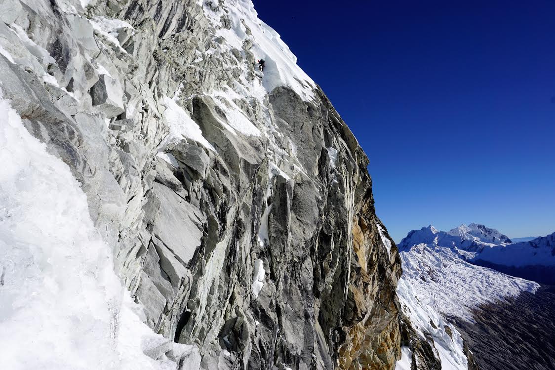 Alik Berg on the reach around traverse that was the key for accessing the headwall. [Photo] Quentin Lindfield Roberts