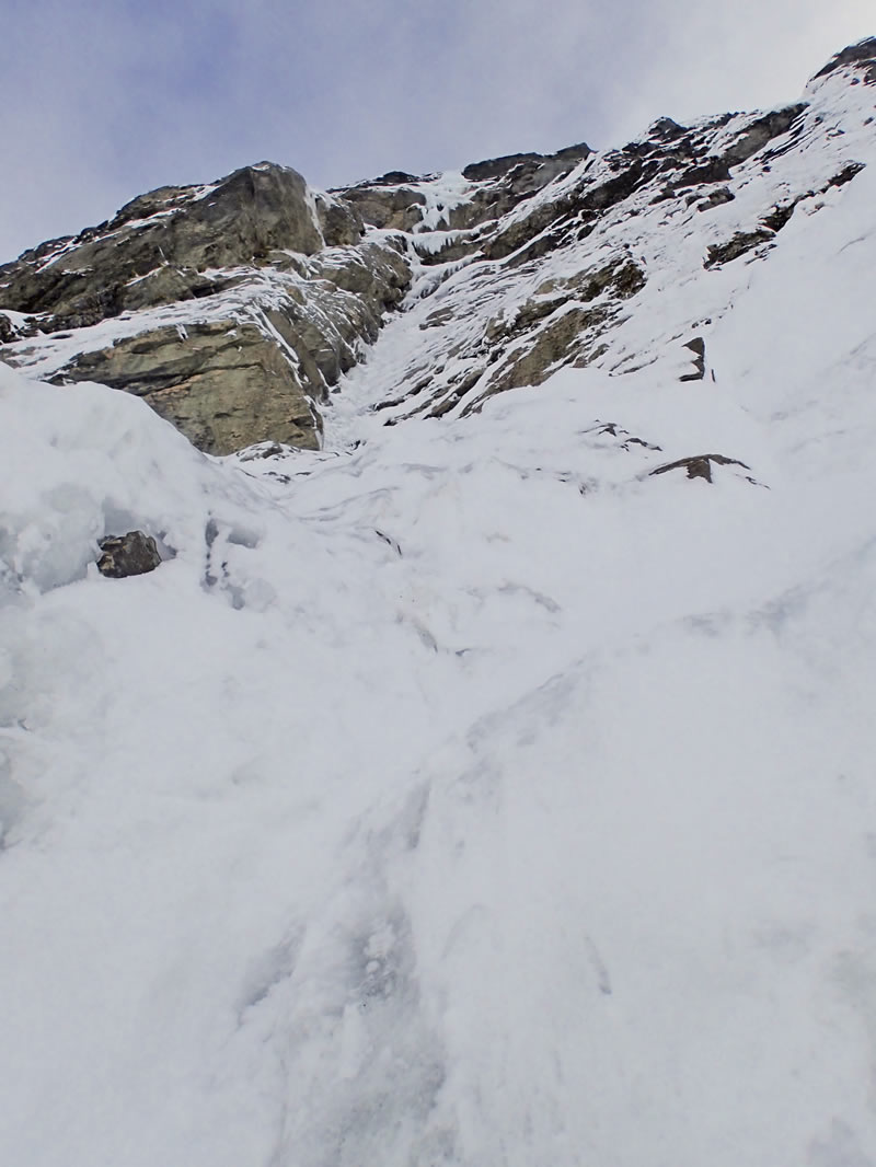 The author looking up into the crux ice pitch. A spectacular pitch of water ice on the upper face! Dare recalls. [Photo] Ben Dare