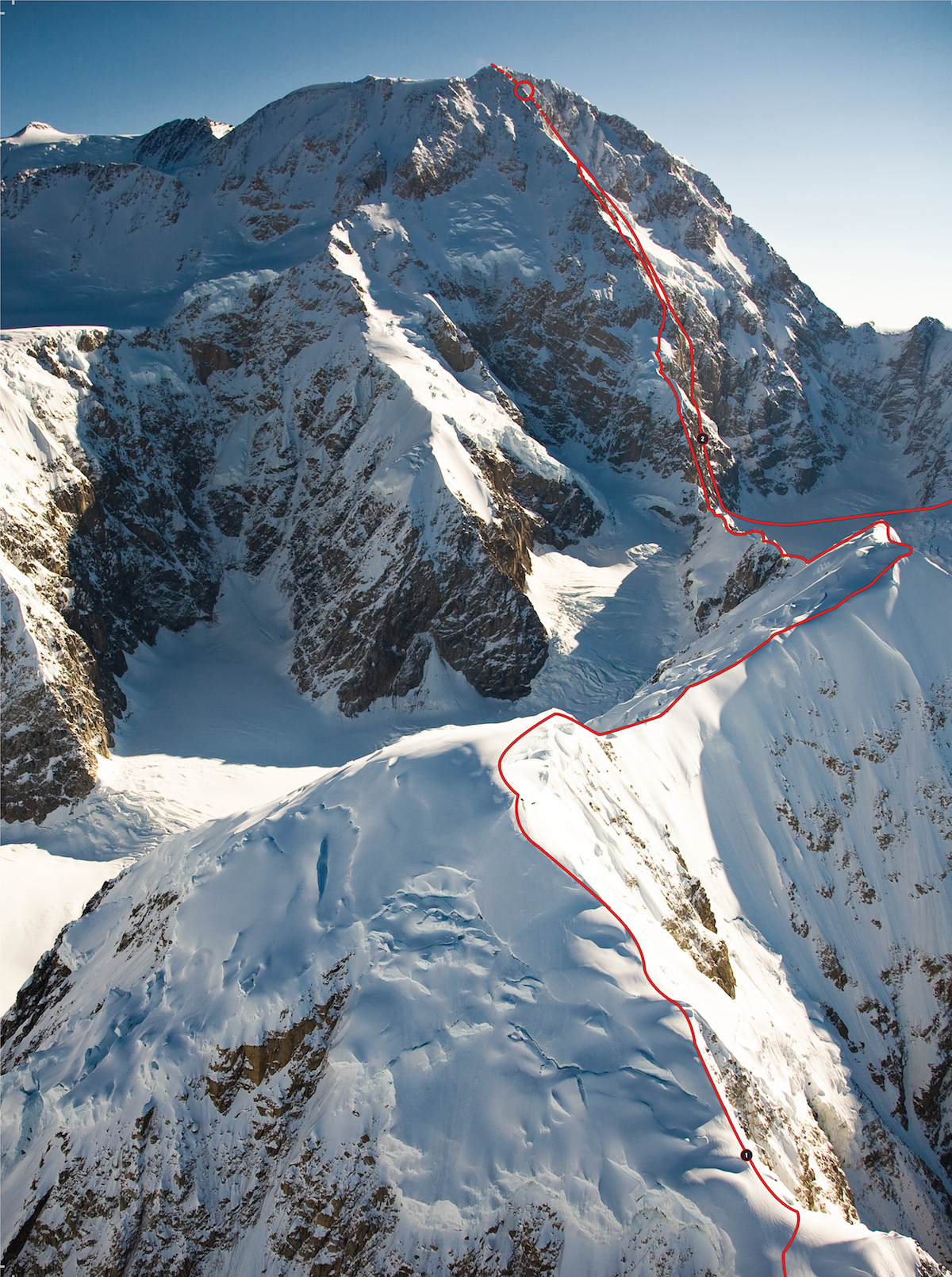 The south face of Denali (20,320'), Alaska Range, Alaska, with the Kahiltna peaks in the foreground, showing 1) the line taken by Tatsuro Tats Yamada and Yuto Inoue on their attempted enchainment of West Kahiltna Peak, East Kahiltna Peak and the Cassin Ridge (Alaska Grade 5: 5.8 AI4 65*, 9,000') (open circle indicates assumed high point). 2) The Slovak Direct (Alaska Grade 6: 5.9 100*, 9,000', Adam-Korl-Krizo, 1984). Fumitaka Itchy Ichimura, Yusuke Sato and Katsutaka Jumbo Yokoyama en chained the Isis Face (Alaska Grade 6: M4 5.8 A1 60*, 7,200' [to the South Buttress], Stutzman-Tackle, 1982) and the Slovak Direct from May 11-18, 2008, descending from the top of the South Buttress via The Ramp Route (Alaska Grade 3: 55*, 9,300', Kajiura- Nakamura-Nishimura, 1965). For a full description of Denali's routes, see Alpinist 24's Mountain Profile. [Photo] National Park Service Photo/Jeff Pflueger
