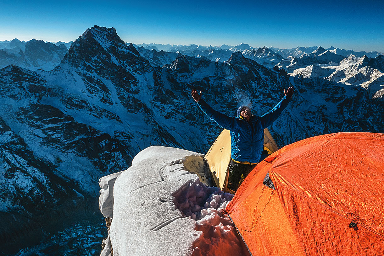Novak, after a calm, clear night on the summit, makes a salutation to the sun. The team descended by the south face and east couloir. This April, the ascent received a Piolet d'Or. [Photo] Marko Prezelj