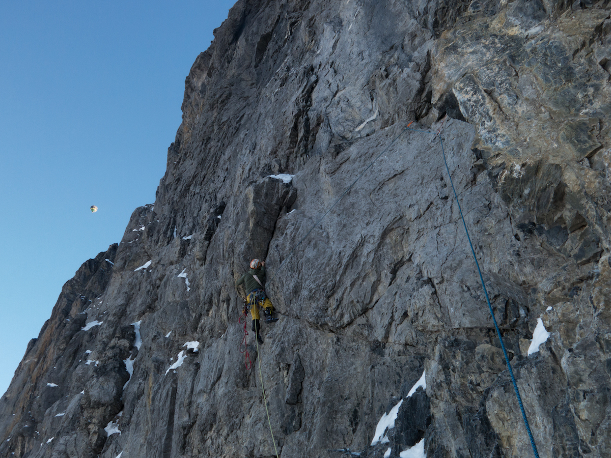 Thomas Huber leads one of the harder pitches of Metanoia as a hot air balloon floats in the distant sky above. [Photo] Archive Metanoia