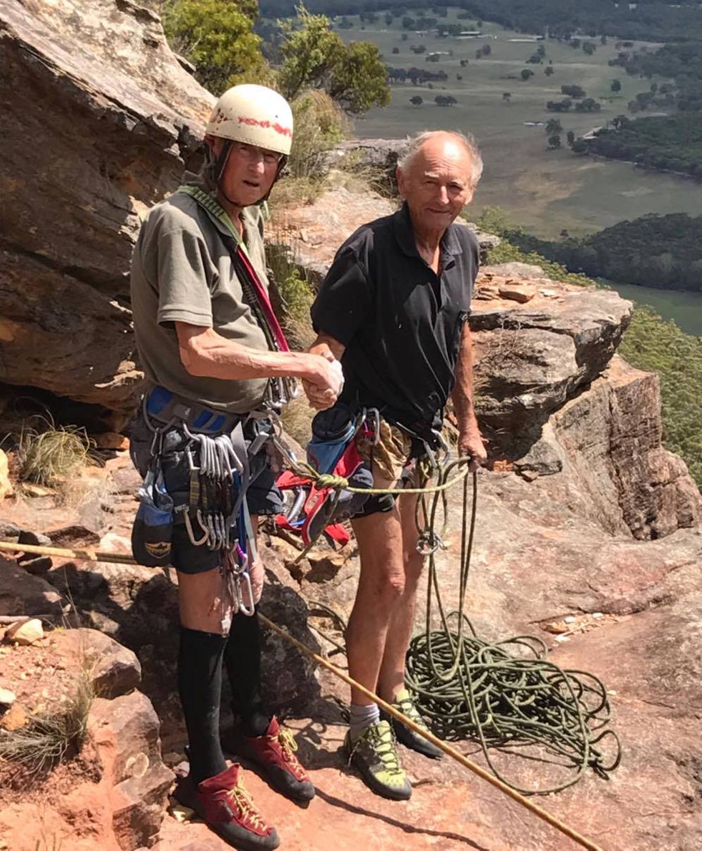 Roland (on left) on New Year's Day, 2017, at the top of his last climb, shaking the hand of his longtime friend and climbing partner, Tony Nemec. [Photo] Ryan Pauligk
