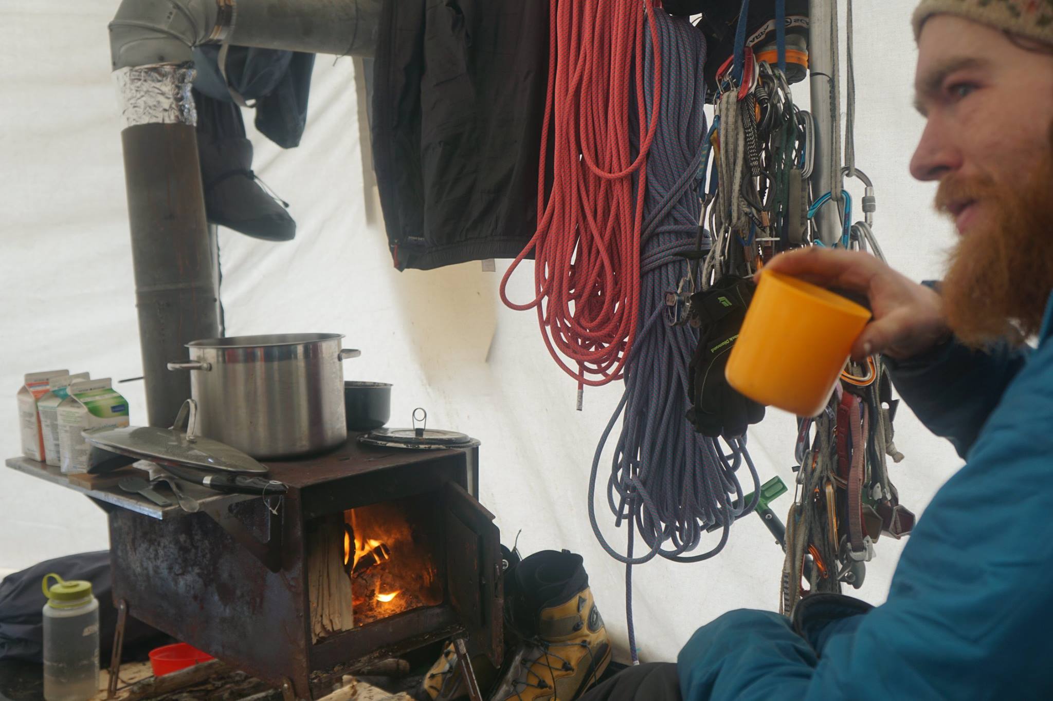 Maarten van Haeren relaxes in the tent. The team used a canvas prospectors tent and wood-fired stove for shelter and warmth on their eight day outing. [Photo] Pete Takeda