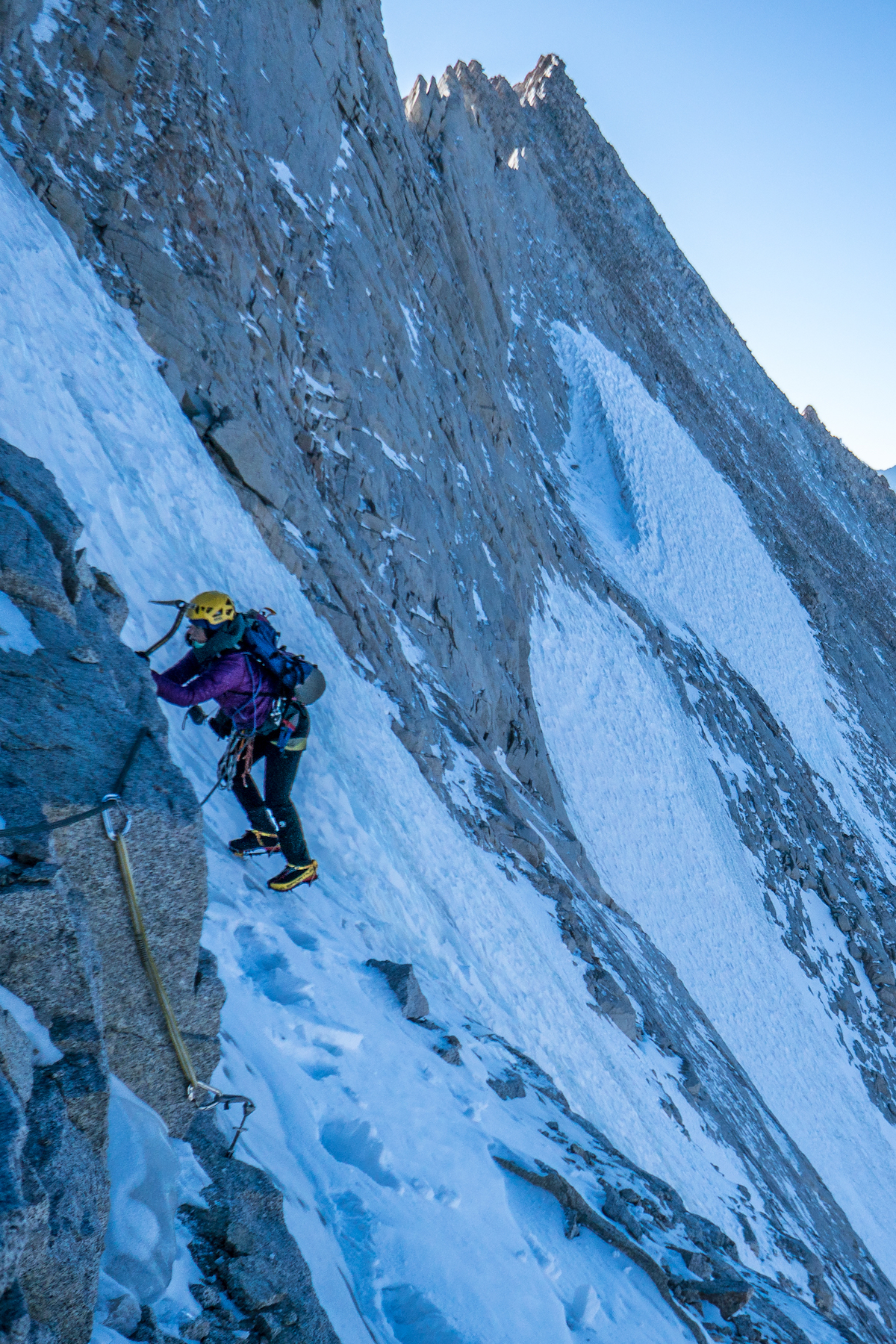 Whitney Clark traverses to the belay after climbing the hanging glacial ice midway up a new route (Land of Milk and Honey, IV 5.8+ M3 R 65 degrees, 1,000') on the northwest face of Mt Russell (14,094') in the Sierra Nevada Range, California. [Photo] Tad McCrea