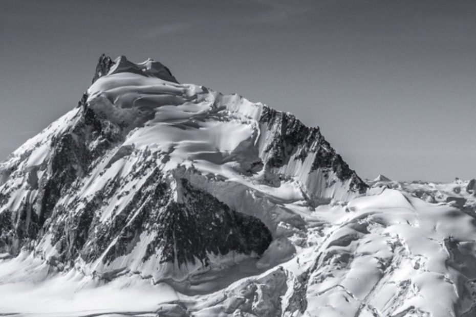 The Epaulette (West) Ridge of Mt. Waddington follows the right skyline. The bergschrund that the climbers jumped down at the end of the ridge below the summit is visible as a shadowed line, just below the horizon on the white slope. [Photo] Courtesy of John Scurlock