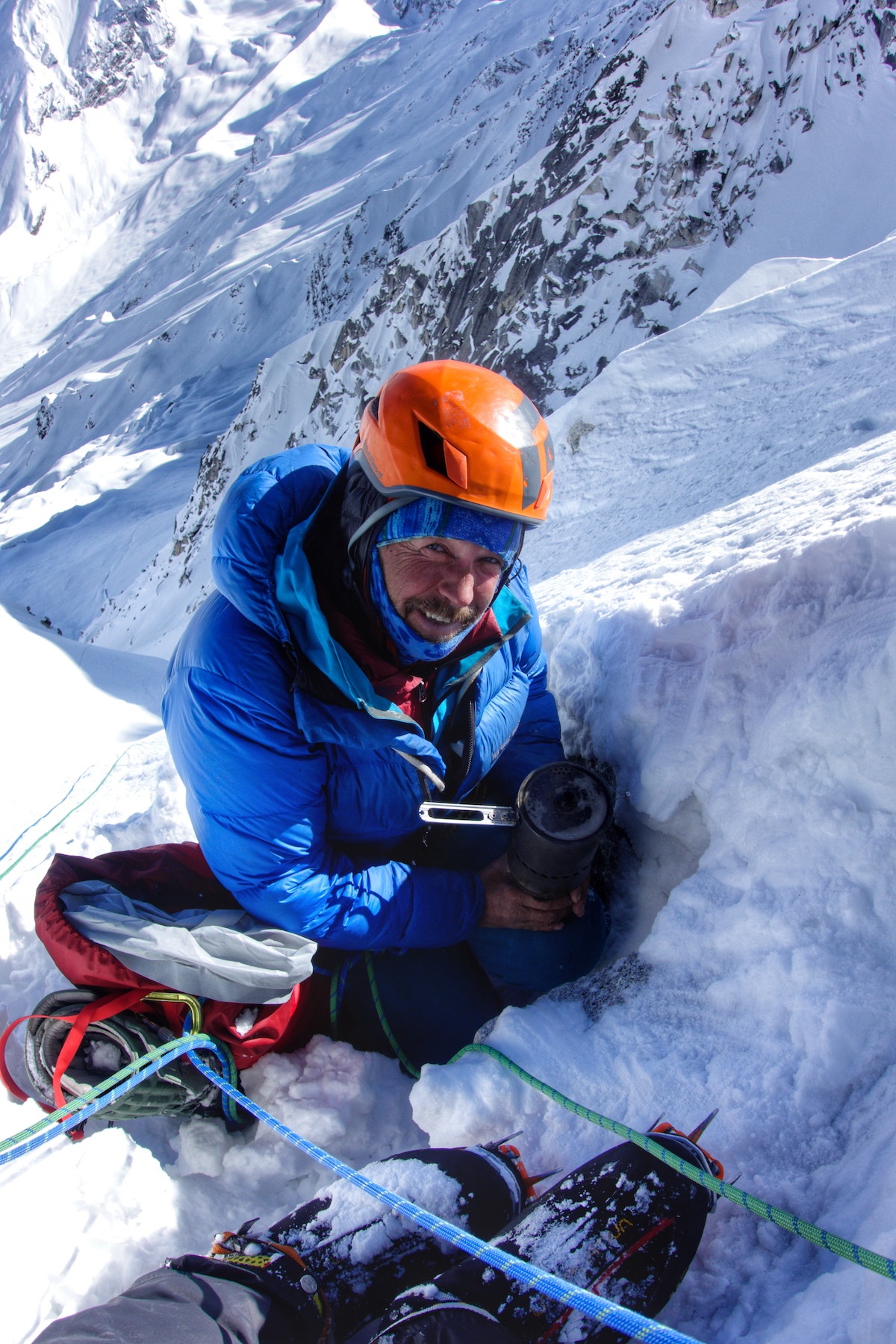 Kelley melts some snow for water while Billet sets up a rappel down the face. [Photo] Benjamin Billet
