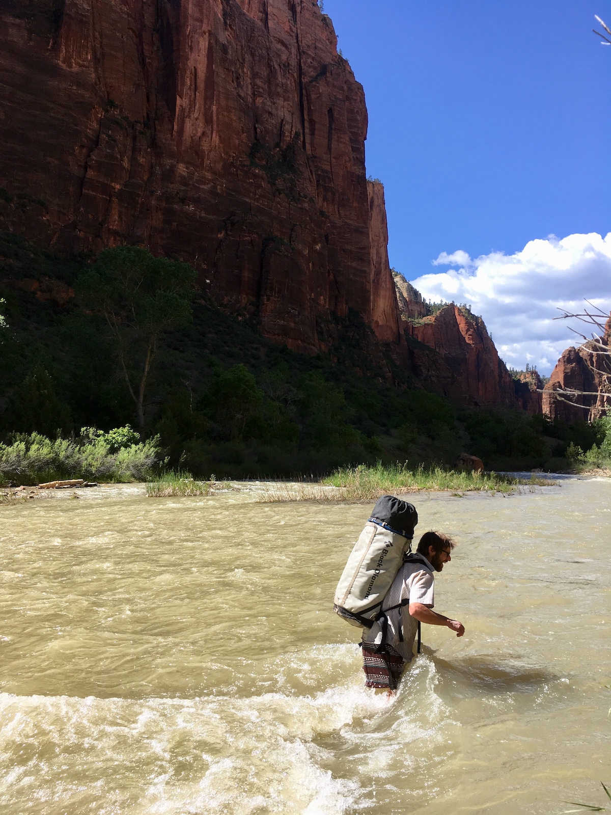 Kalman crossing a swollen Virgin River after climbing Moonlight Buttress. The Octapod fit neatly inside the medium-size haul bag seen here, along with sleeping gear, personal climbing gear, a rack, helmet and poo bag. [Photo] Nelson Klein