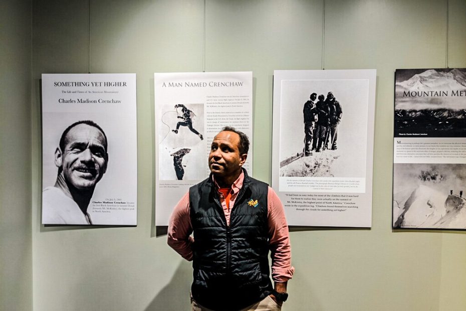 James Edward Mills stands in front of his exhibit featuring African American mountaineer Charles Madison Crenchaw at the Bradford Washburn American Mountaineering Museum, in Golden, Colorado. [Photo] Courtesy of James Edward Mills