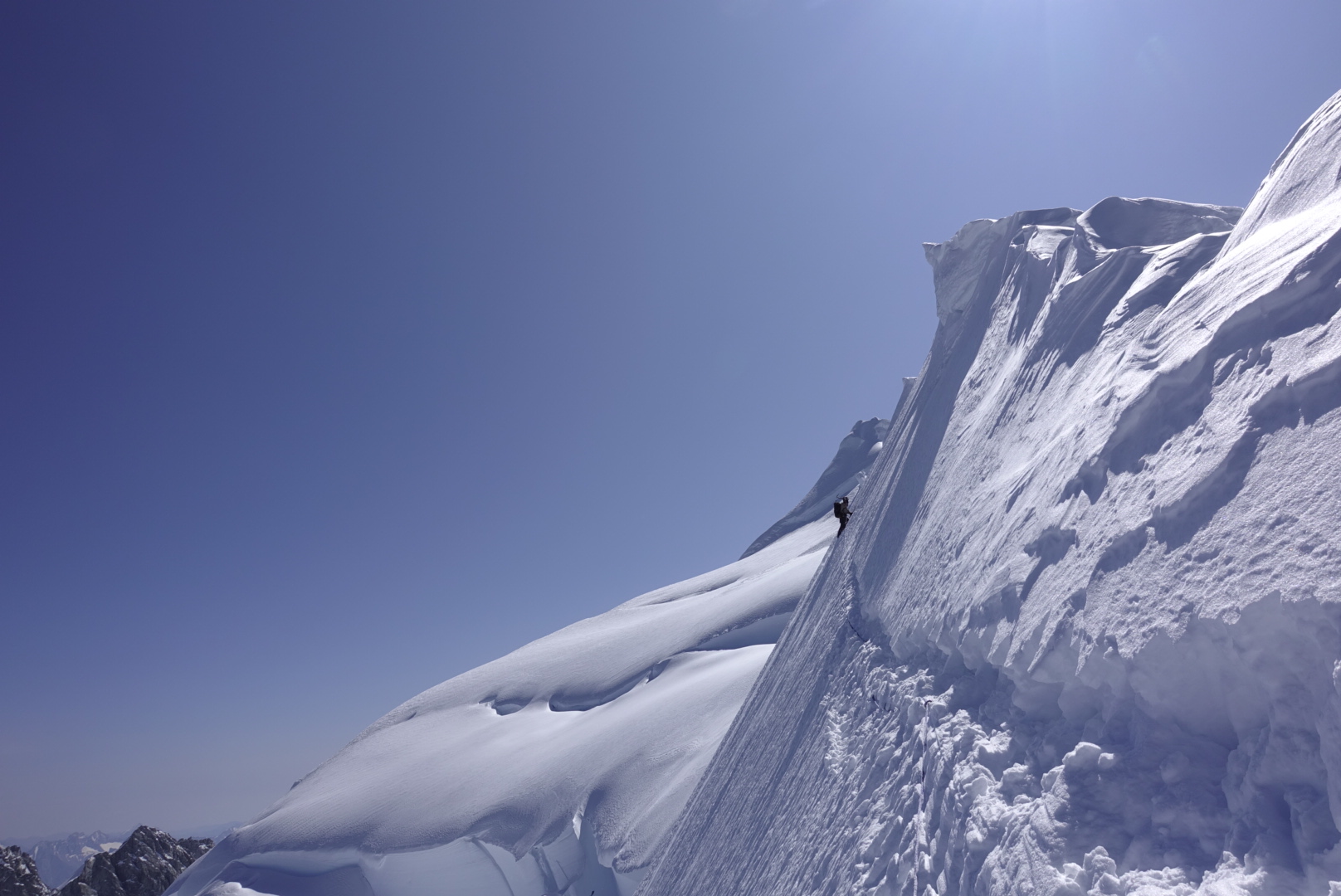 Ian Welsted on the traverse at the end of the Epaulette Ridge. The sloping shelf of Angel Glacier is below with Waddington's northwest summit in background. [Photo] Simon Richardson